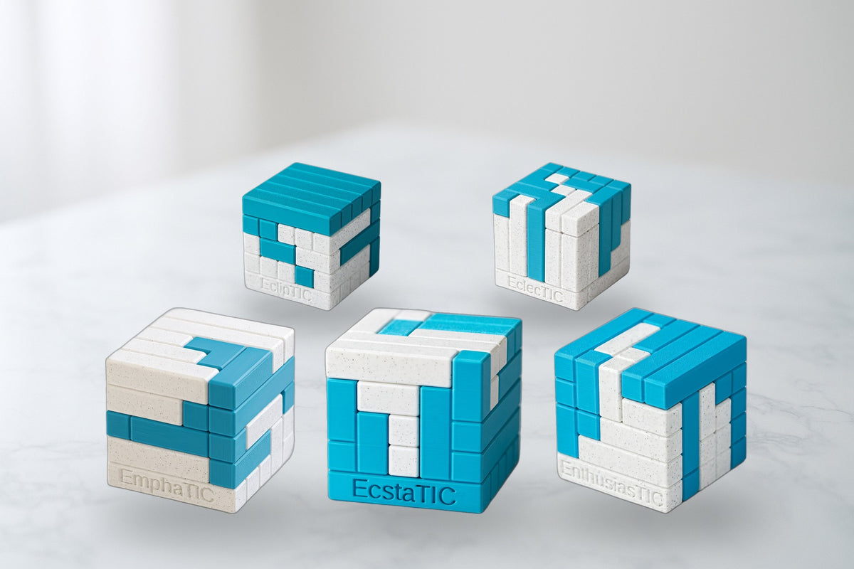 Two-Piece TIC Collection - five 3D-printed turning interlocking cube puzzles on marble.