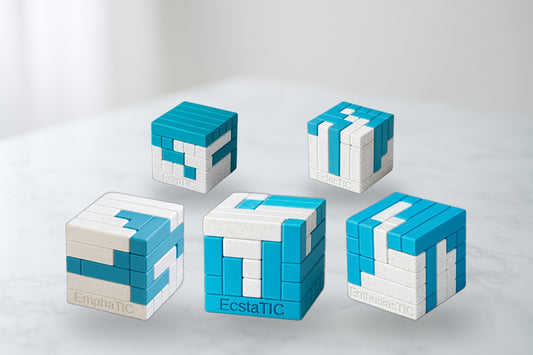 Two-Piece TIC Collection - five 3D-printed turning interlocking cube puzzles on marble.